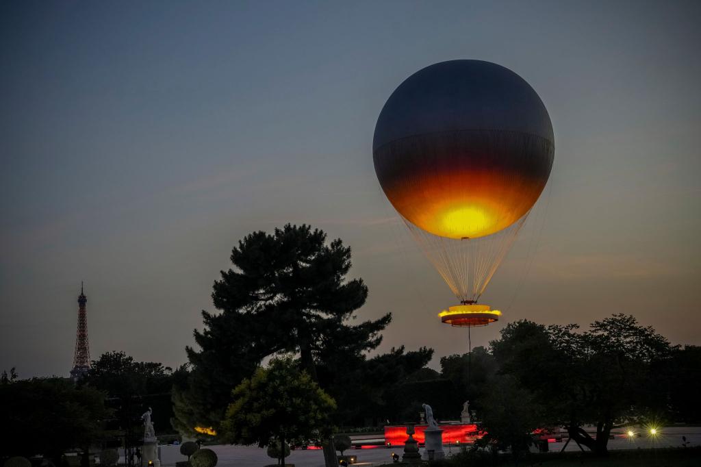 Viele Menschen in Paris hatten sich gewünscht, dass der olympische Ballon wieder in die Stadt zurückkehrt. - Foto: Aurelien Morissard/AP/dpa