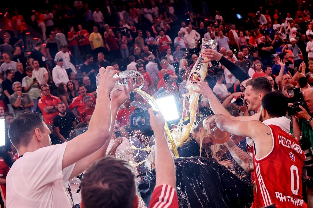 Die Bayern-Basketballer überschütten Coach Herbert mit Bier. - Foto: Matthias Stickel/dpa