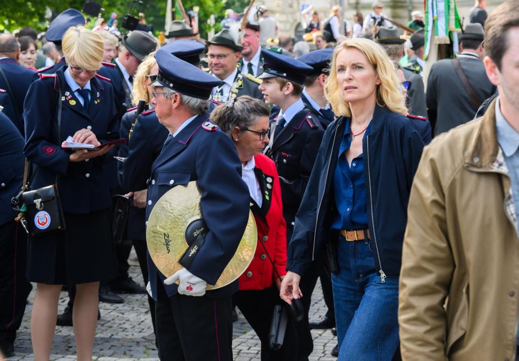 Die Schauspielerin Maria Furtwängler steht bei Dreharbeiten für einen neuen fiktiven „Tatort“ inmitten des realen Schützenausmarsches am Neuen Rathaus. - Foto: Julian Stratenschulte/dpa