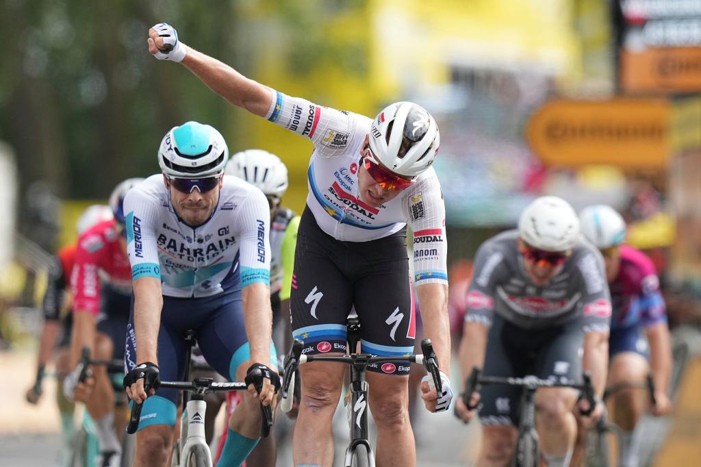 Tim Merlier feiert den Etappensieg, der deutsche Sprinter Phil Bauhaus (L.) freut sich über den dritten Rang. - Foto: Thibault Camus/AP/dpa