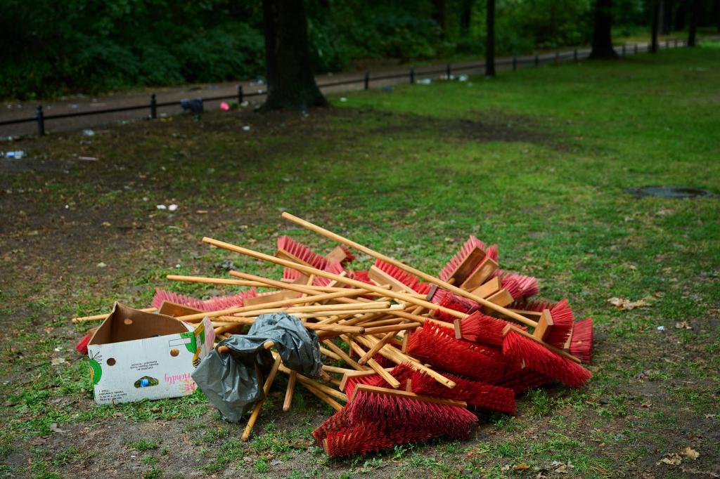 Rote Besen liegen neben der Straße des 17. Juni in Berlin bei den Aufräumarbeiten nach der Techno-Parade «Rave The Planet». - Foto: Annette Riedl/dpa