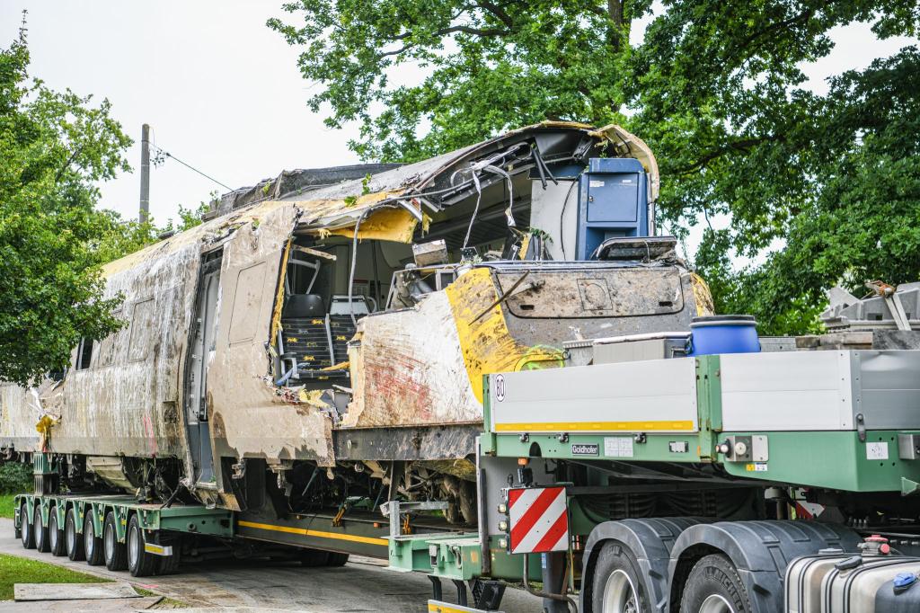Ein Waggon ist zum Abtransport auf einen Tieflader verladen worden. - Foto: Jason Tschepljakow/dpa