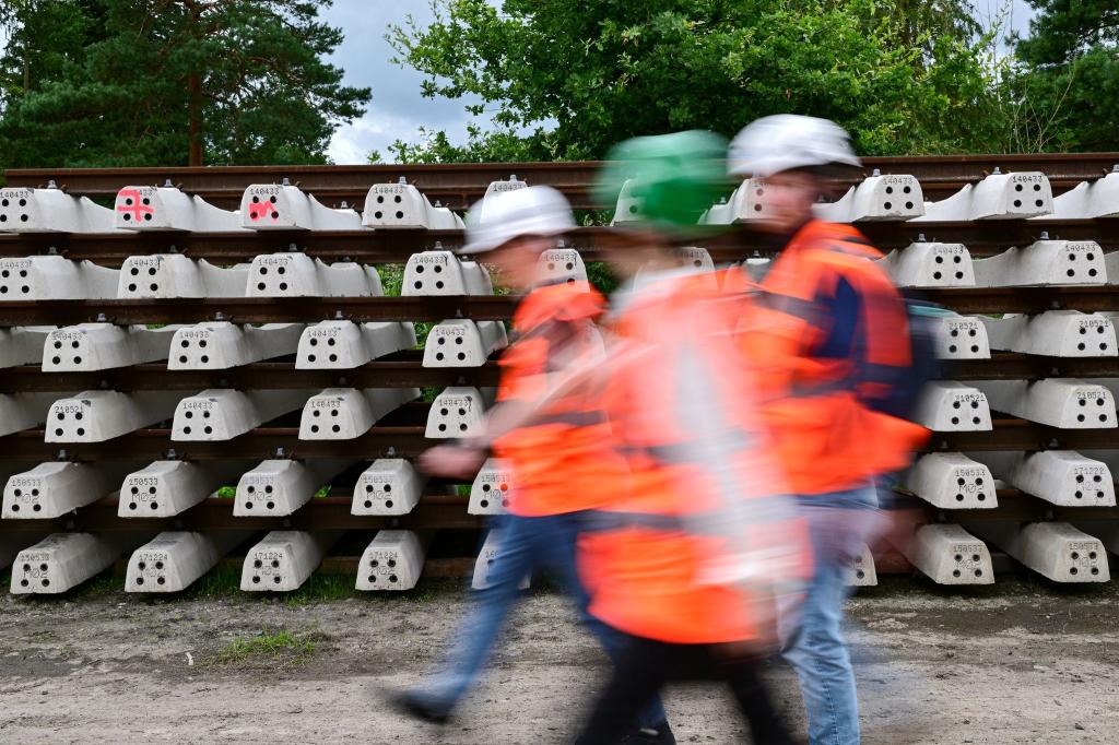 Baustellenbesucher gehen während der Generalsanierung der Bahnstrecke Hamburg - Berlin an neuen Schienen vorbei. - Foto: Sebastian Christoph Gollnow/dpa