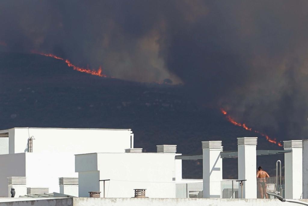 Schwarzer Rauch steigt in den Himmel während eines Brandes an der Costa de la Luz in Südspanien. - Foto: Nono Rico/EUROPA PRESS/dpa