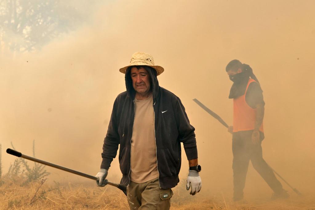 Menschen reagieren bei der Bekämpfung eines Waldbrandes in Veiga das Meas im Nordwesten Spaniens. - Foto: Lalo R. Villar/AP/dpa