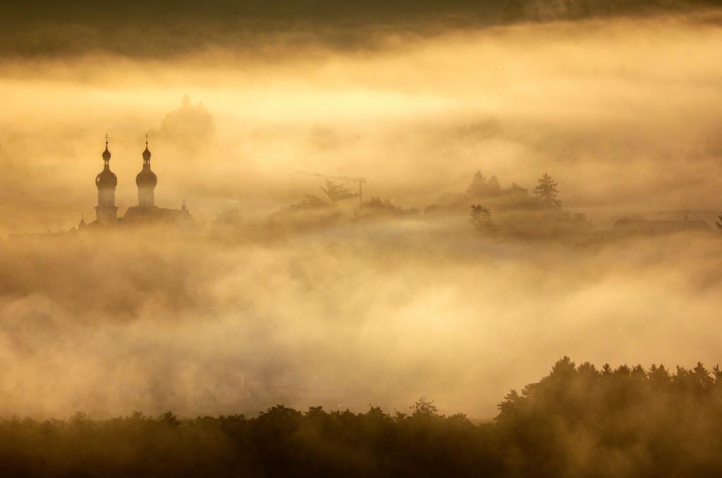 Die Türme St. Simon und Juda stehen im Morgennebel. - Foto: Thomas Warnack/dpa