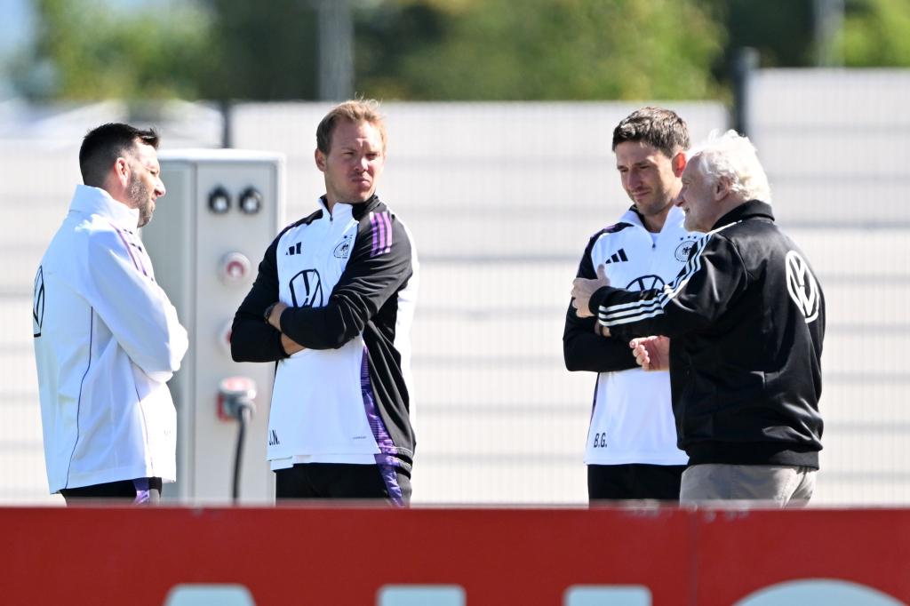 Sportdirektor Rudi Völler (r.) spricht mit Bundestrainer Julian Nagelsmann (2.v.l.) vor dem Training. - Foto: Federico Gambarini/dpa