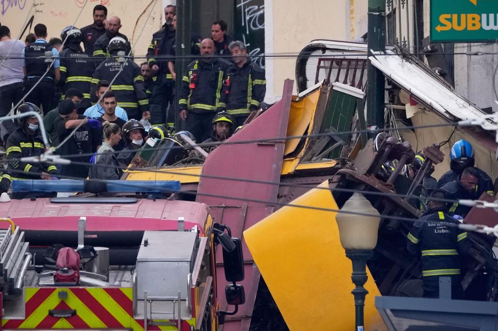 Rettungskräfte arbeiten in Lissabon an der Stelle, an der eine Standseilbahn entgleist ist. - Foto: Armando Franca/AP/dpa