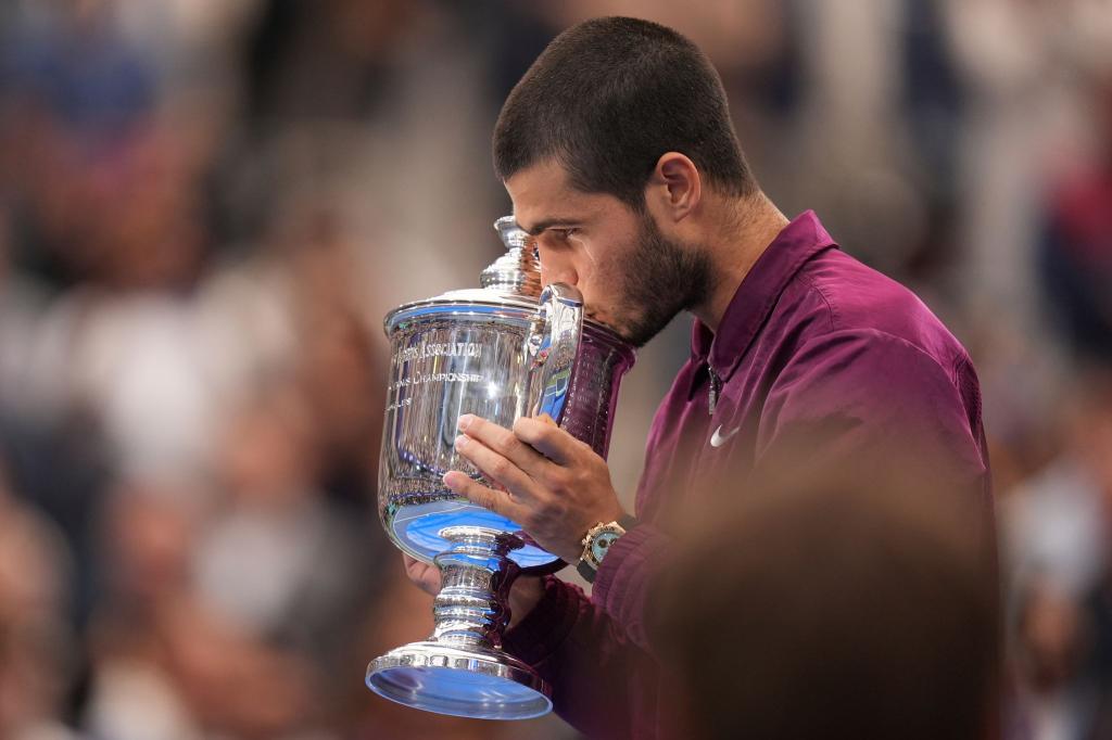 Ein Küsschen für den Pokal: Alcaraz ist neuer US-Open-Champion. - Foto: Seth Wenig/AP/dpa