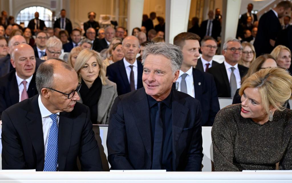 Zum ersten Mal gemeinsam beim Einheitsfest: Bundestagspräsidentin Julia Klöckner (CDU) mit ihrem Lebensgefährten Jörg Pilawa (M.) - im Gespräch mit Bundeskanzler Friedrich Merz (CDU) in der Ludwigskirche. - Foto: Jean-Christophe Verhaegen/POOL AFP/dpa