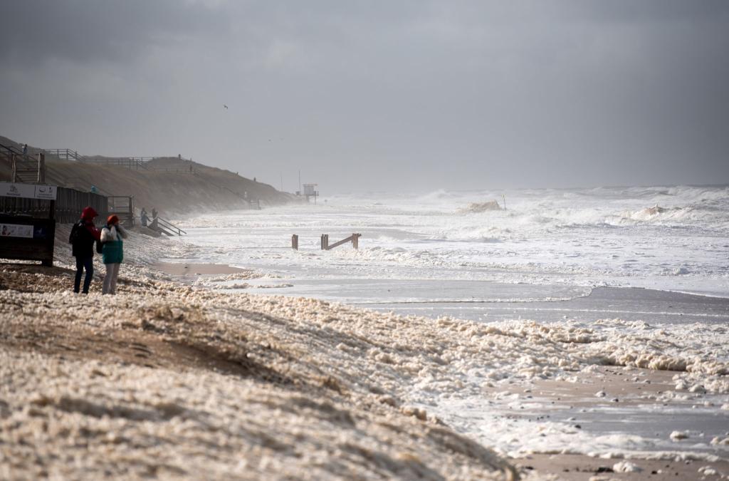 Sturmflut vor Sylt. Das Wetter lockte auch Spaziergänger an die Nordsee. - Foto: Daniel Bockwoldt/dpa