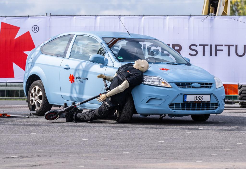 Crashtest mit einem E-Scooter: Ein abbiegendes Auto erfasst den Dummy - der prallt hart auf den Wagen. - Foto: Guido Kirchner/dpa