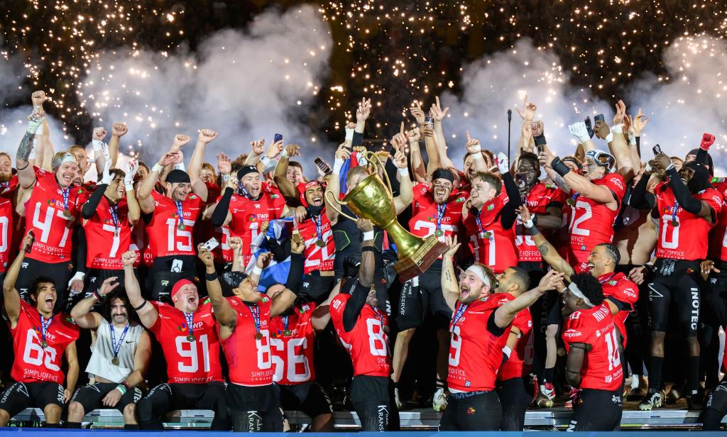 Die Potsdam Royals werden in Dresden Deutscher Meister im American Football und jubeln mit dem Pokal. - Foto: Robert Michael/dpa