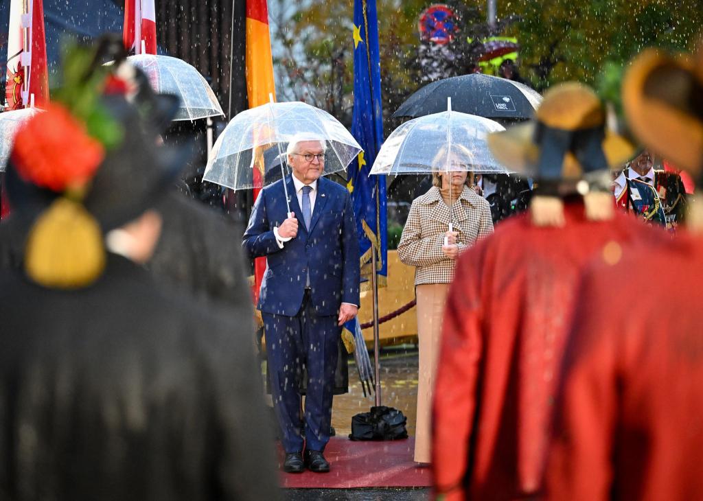 Bundespräsident Frank-Walter Steinmeier und seine Ehefrau Elke Büdenbender nehmen im strömenden Regen am landesüblichen Empfang durch die Tiroler Schützenkompanie teil. - Foto: Soeren Stache/dpa