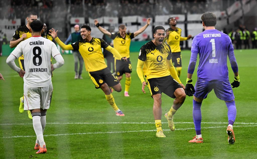 Die Dortmunder Spieler stürmen auf Elfmeter-Held Kobel zu. - Foto: Arne Dedert/dpa