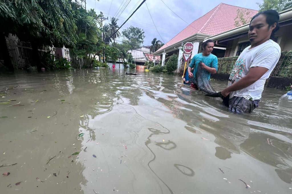 Die Menschen mussten teilweise durch hüfthohes Wasser waten. - Foto: Jacqueline Hernandez/AP/dpa