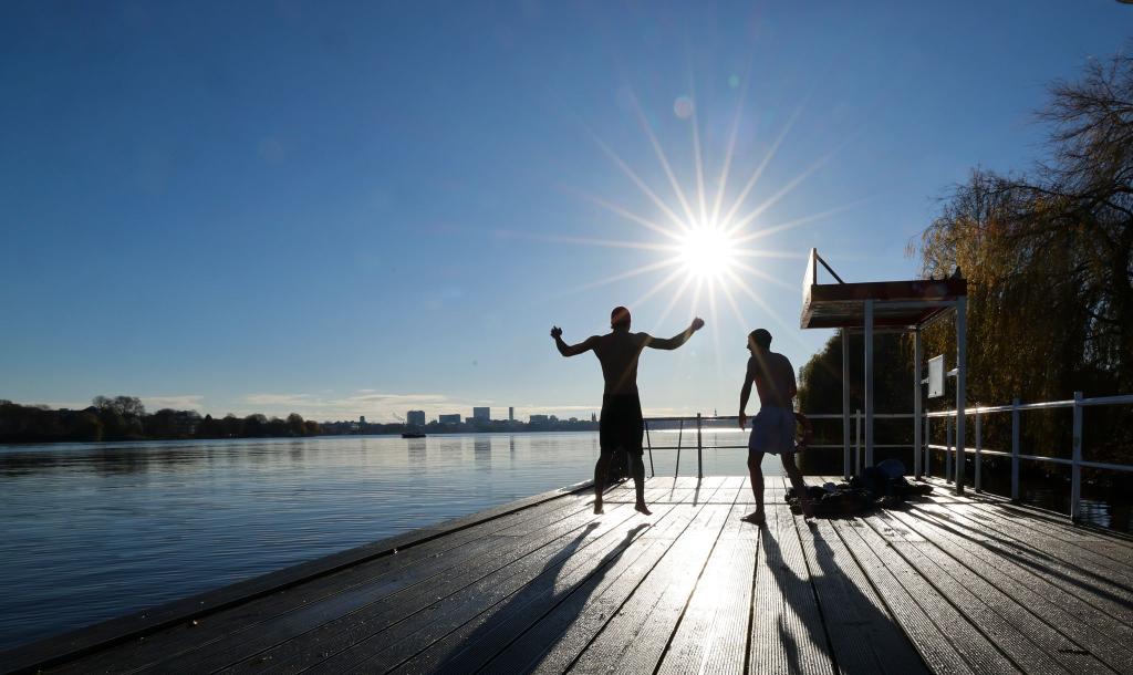 Zwei junge Männer haben Spaß beim Eisbaden in Hamburg an der Alster. - Foto: Christian Charisius/dpa