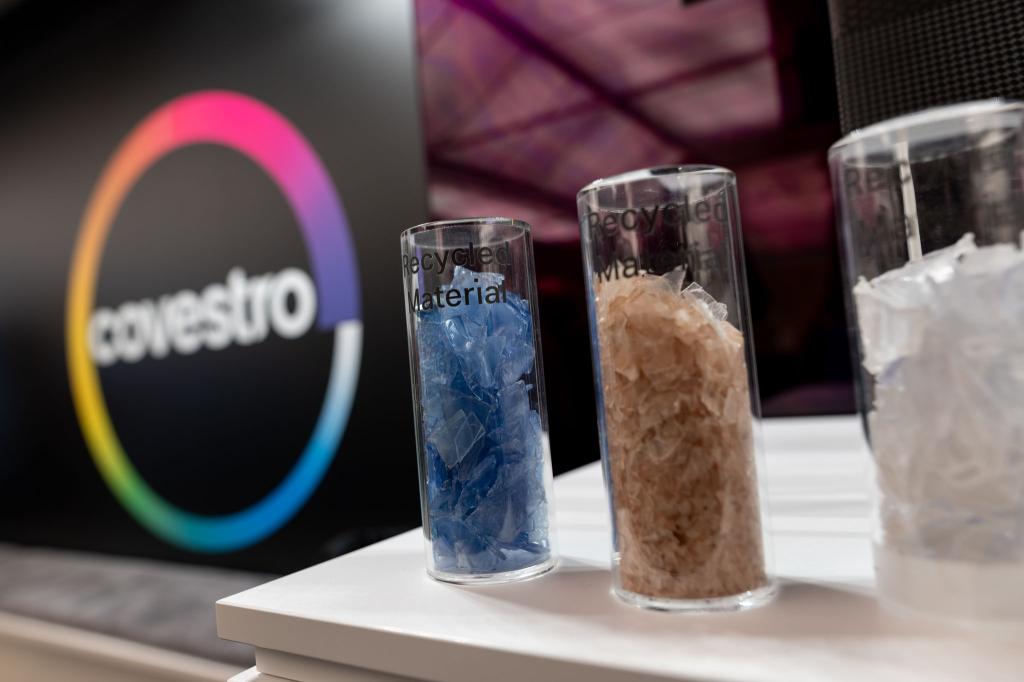 Eine deutsche Firma wird arabisch: Das Logo des Spezialchemie-Konzerns in einem Firmen-Showroom, davor Gläser mit Covestro-Materialien. - Foto: Fabian Strauch/dpa