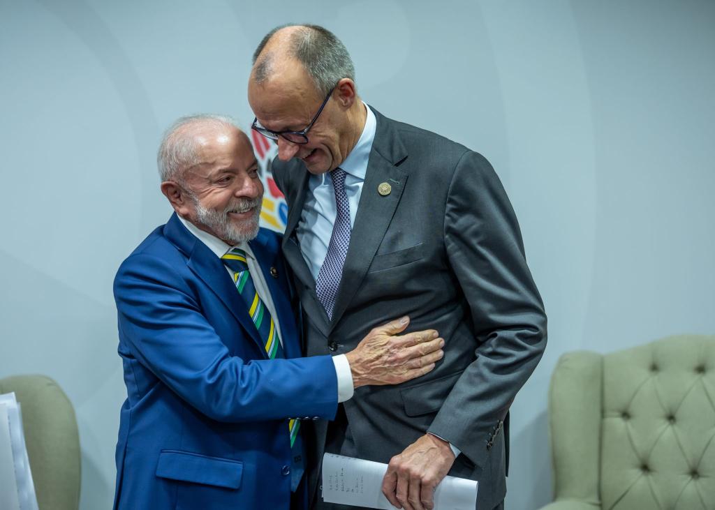 Kanzler Merz und Brasiliens Präsident Lula umarmen sich beim G20-Gipfel. - Foto: Michael Kappeler/dpa-pool/dpa