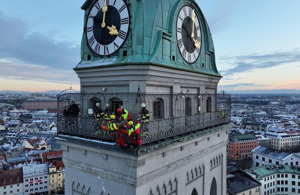Kräfte der Berufsfeuerwehr München sind am Turm der Kirche St. Peter im Einsatz. - Foto: -/Berufsfeuerwehr München/dpa