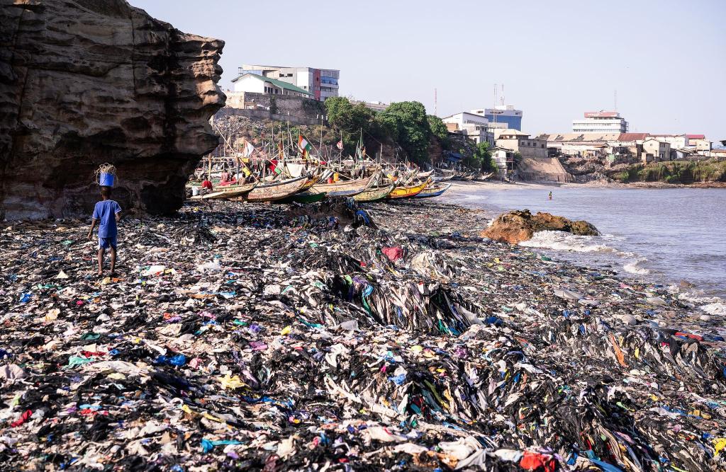 Ein Sandstrand, dessen Sand gar nicht mehr zu sehen ist: Massen an Klamotten vermüllen diesen Küstenabschnitt von Accra. - Foto: Kevin McElvaney/Deutsche Umwelthilfe/dpa
