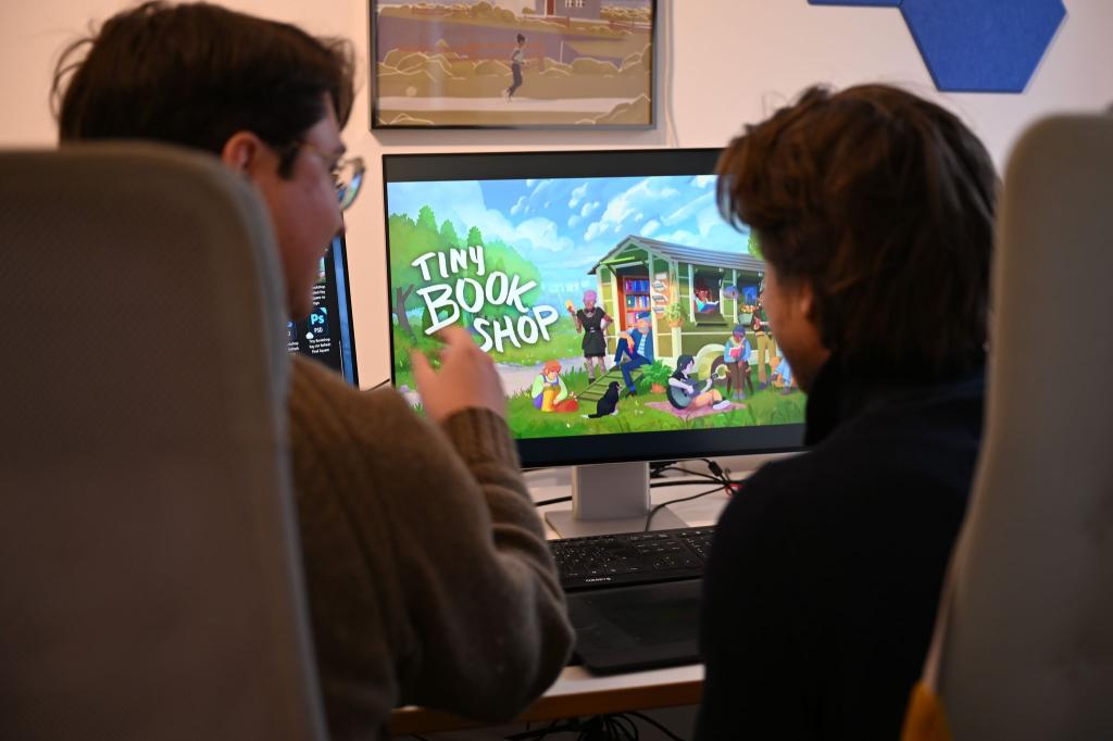 Als Bachelor-Arbeit an der Uni entstanden, inzwischen ein großer Verkaufserfolg: Das Spiel «Tiny Bookshop» mit ihren beiden Entwicklern David Zapfe-Wilde (links) und Raven Rusch. - Foto: Wolf von Dewitz/dpa