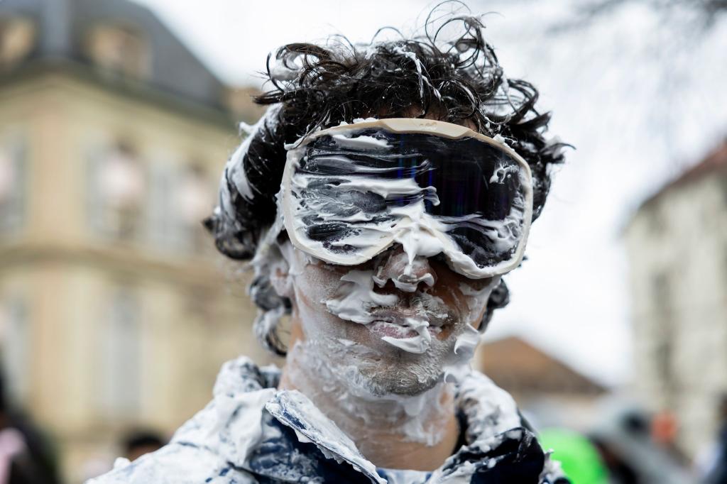 Ein Teilnehmer ist beim "Picoulet" in Genf verkleidet und voller Rasierschaum. Bei dem traditionellen bunten Umzug mit Musik kommt es oft zu wahren Schaumschlachten. - Foto: Salvatore Di Nolfi/KEYSTONE/dpa