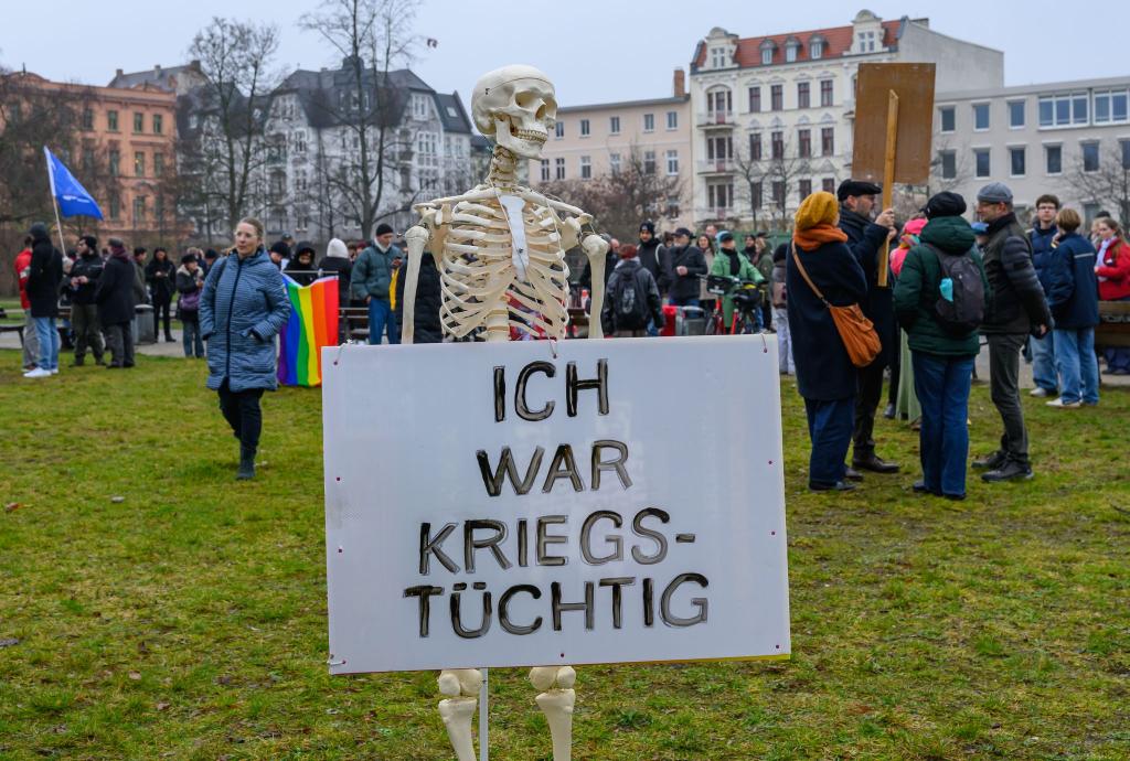 Bis auf die Knochen: Mit einem Skelett wird in Cottbus gegen eine mögliche Wehrpflicht demonstriert. - Foto: Patrick Pleul/dpa