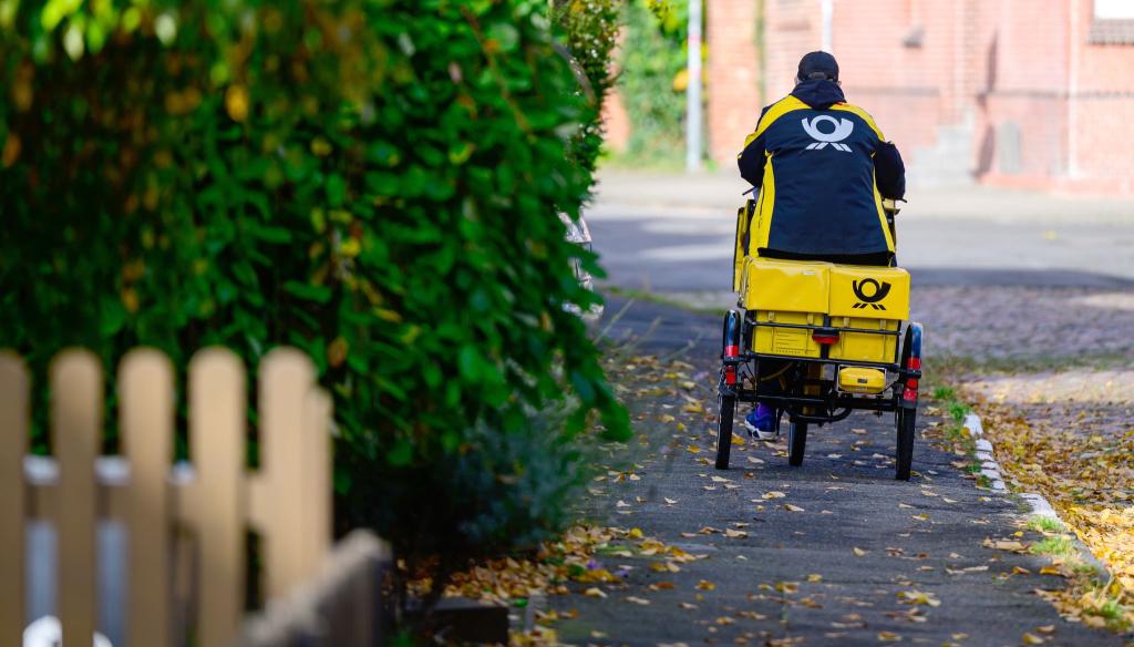 Ein Briefträger bei der Arbeit. - Foto: Philipp Schulze/dpa