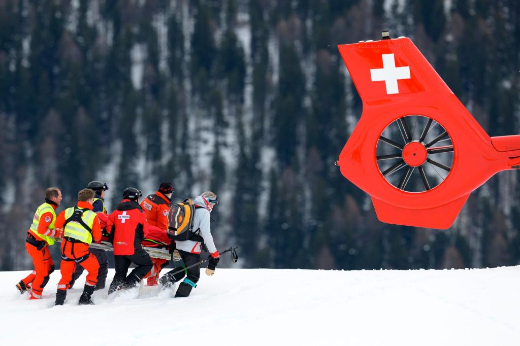 Michelle Gisin wird nach ihrem Sturz in St. Moritz zum Rettungshubschrauber gebracht. - Foto: Jean-Christophe Bott/KEYSTONE/dpa