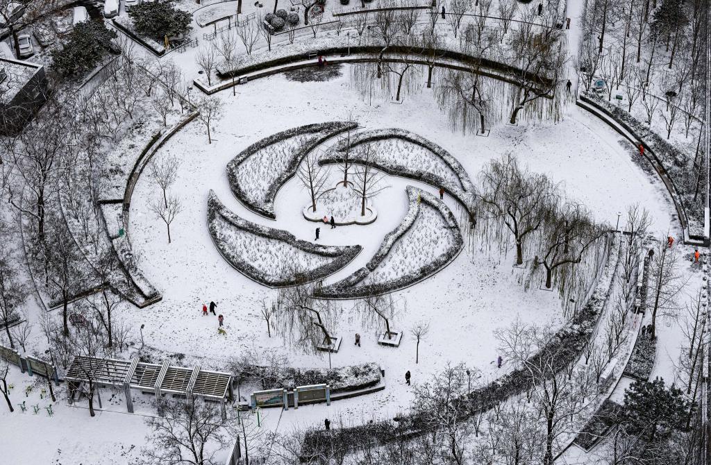 Menschen haben Spaß im Schnee in einem Park in Peking. - Foto: Chen Yehua/XinHua/dpa