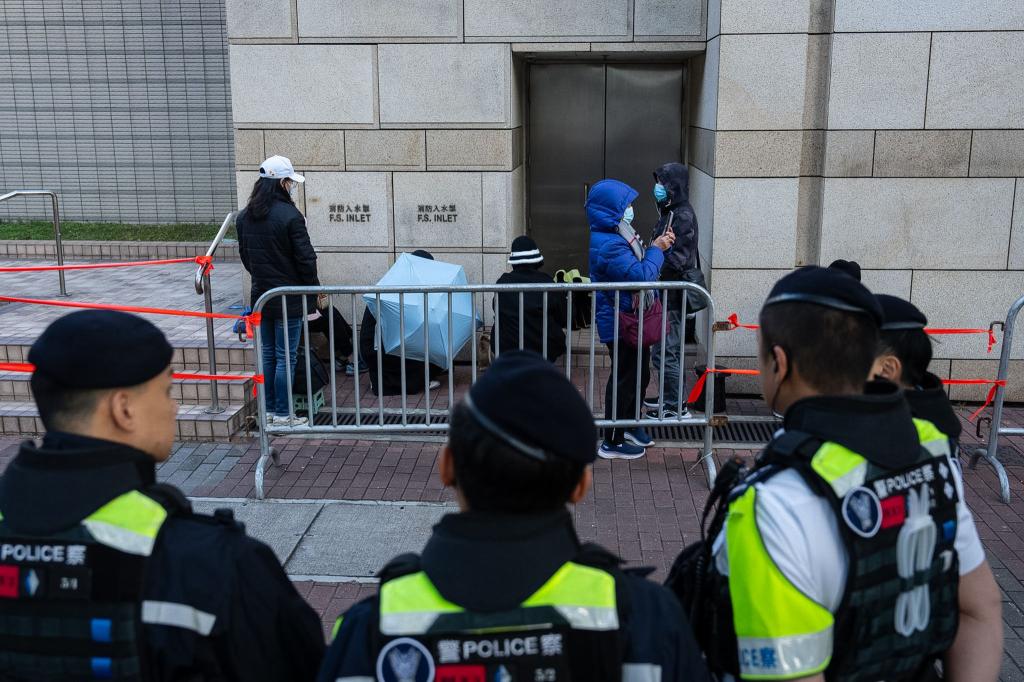 Menschen warten vor dem West Kowloon Magistrates' Courts auf die Urteilsverkündung gegen den Hongkonger Aktivisten und Verleger Jimmy Lai. - Foto: Chan Long Hei/AP/dpa