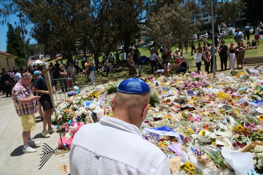 Menschen legen bei einer Gedenkfeier für die Opfer eines Terrorangriffs am Bondi Beach in Sydney Blumen nieder. (Foto aktuell) - Foto: Flavio Brancaleone/AAP/dpa