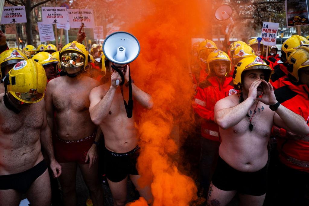 Spanische Feuerwehrleute demonstrieren in Badehosen in Barcelona. - Foto: Lorena Sopêna/EUROPA PRESS/dpa