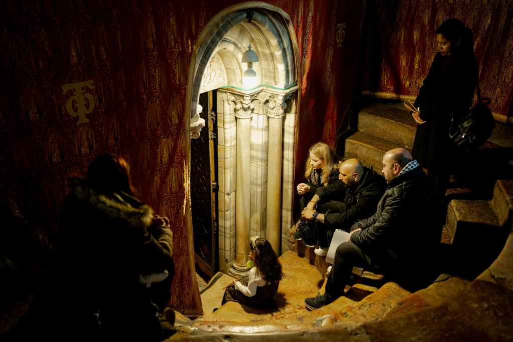 Christen sitzen auf den Stufen der Grotte unter der Basilika, dem angeblichen Geburtsort Jesu Christi, in der Geburtskirche in Bethlehem. - Foto: Erik Marmor/dpa