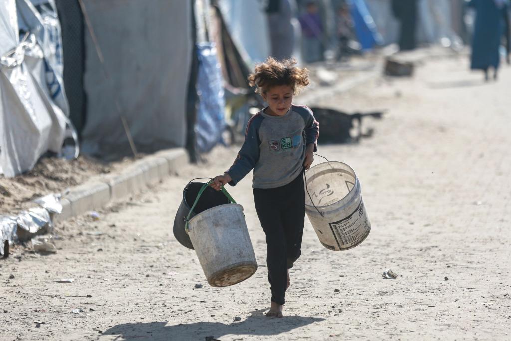 Wasser wird zum Luxus: Kind rennt mit leeren Eimern zu einer Wasserstelle in Gaza - Foto: Omar Ashtawy/APA Images via ZUMA Press Wire/dpa