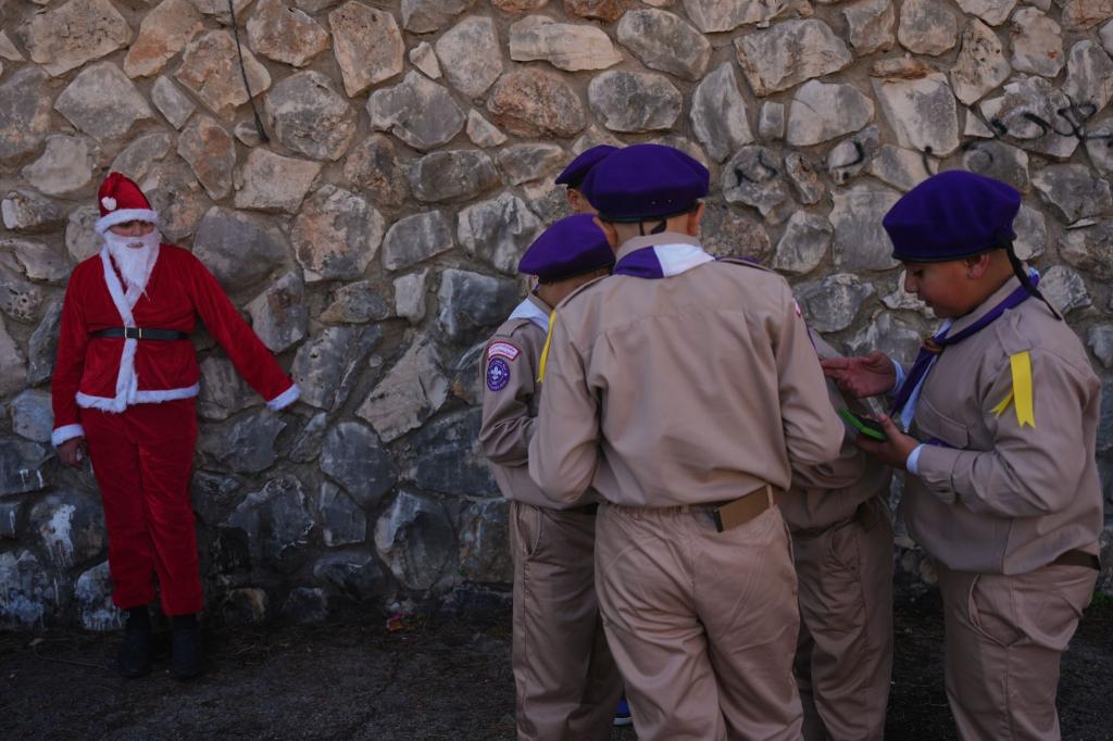 Weihnachten in Nazareth - Jugendlicher im Weihnachtsmannkostüm wartet mit Pfadfindern auf Weihnachtsparade - Foto: Ariel Schalit/AP/dpa