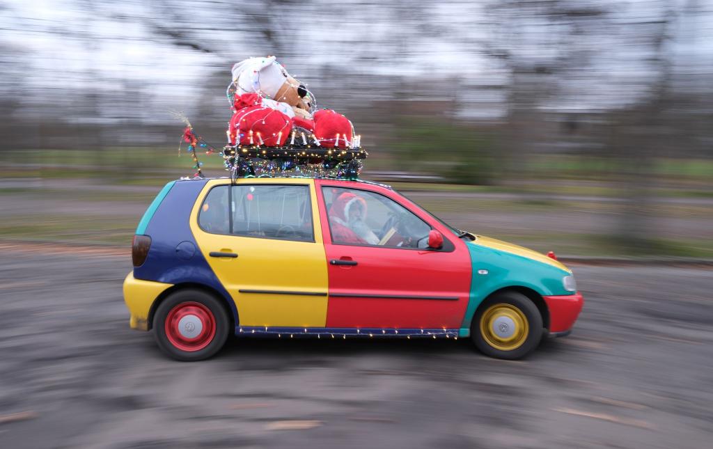 Ein Auto vom Typ Volkswagen Polo in der Edition Harlekin aus dem Jahr 1996 fährt weihnachtlich dekoriert durch Leipzig. - Foto: Sebastian Willnow/dpa