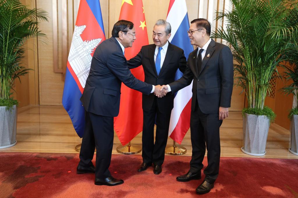 Der kambodschanische Außenminister Prak Sokhonn (l) schüttelt die Hand seines thailändischen Amtskollegen Sihasak Phuangketkeow (r) vor dem chinesischen Amtskollegen Wang Yi. - Foto: Uncredited/Agence Kampuchea Press/AP/dpa