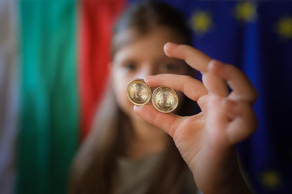 Ein Mädchen zeigt neue Euro-Münzen mit bulgarischen Symbolen. - Foto: Valentina Petrova/AP/dpa