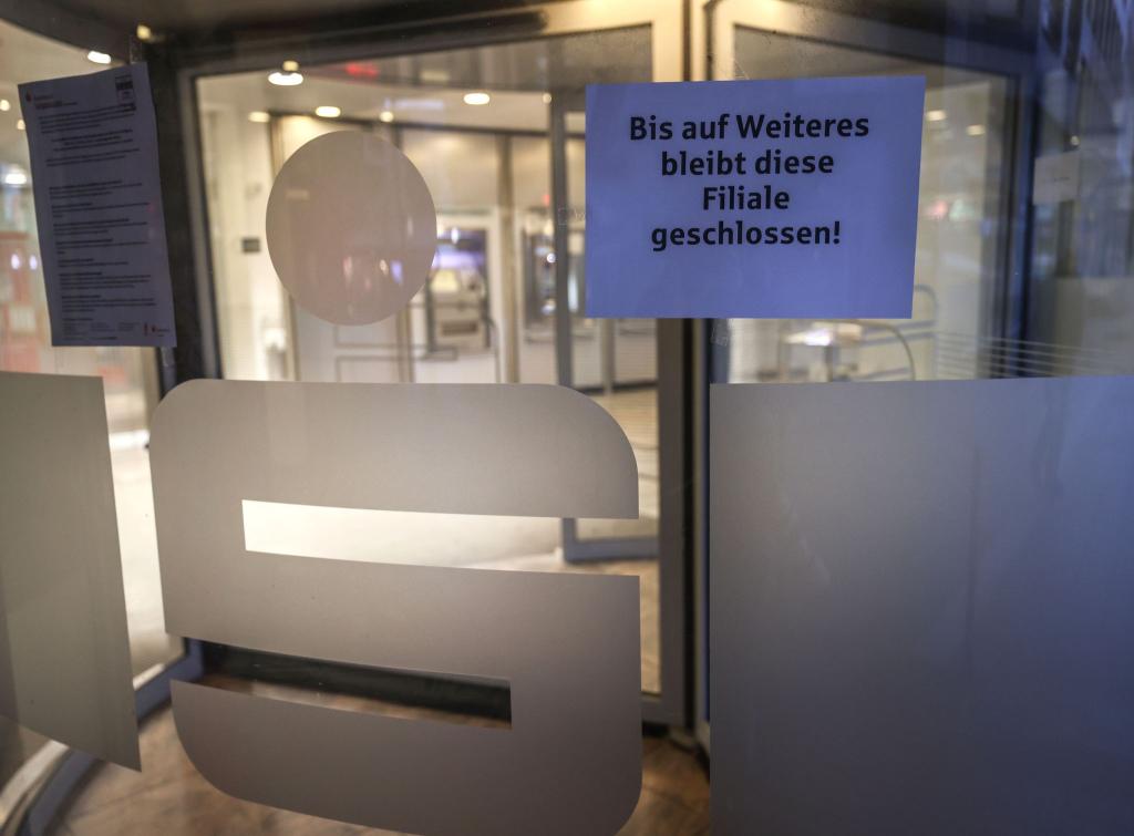 Ein Zettel mit der Aufschrift «Bis auf Weiteres bleibt diese Filiale geschlossen» hängt am Eingang der Sparkassen-Filiale Gelsenkirchen-Buer. - Foto: Oliver Berg/dpa
