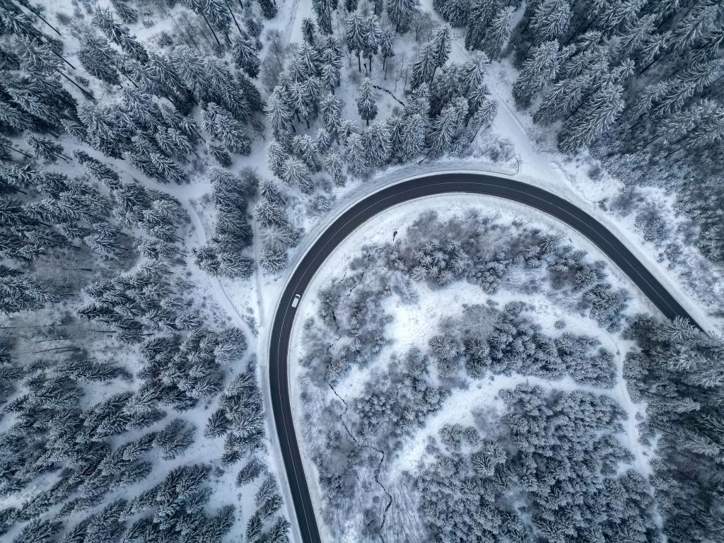 Ein Auto fährt auf einer Landstraße durch den winterlichen Wald im Vogtland. - Foto: Jan Woitas/dpa