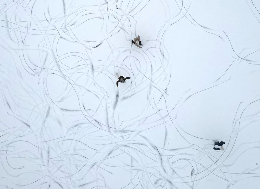 Muster im Schnee: Eine Luftaufnahme zeigt Schlittschuhläufer auf einem zugefrorenen See in Österreich. - Foto: Helmut Fohringer/APA/dpa