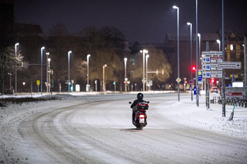 Motorroller kämpft sich am frühen Morgen durch Schnee im Stadtzentrum in Hannover - Foto: Moritz Frankenberg/dpa