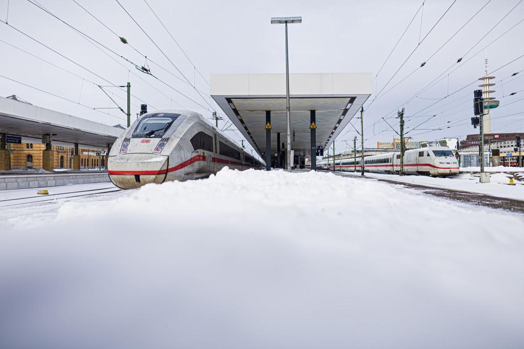 Zwei ICE stehen im verschneiten Hauptbahnhof Hannover. - Foto: Moritz Frankenberg/dpa