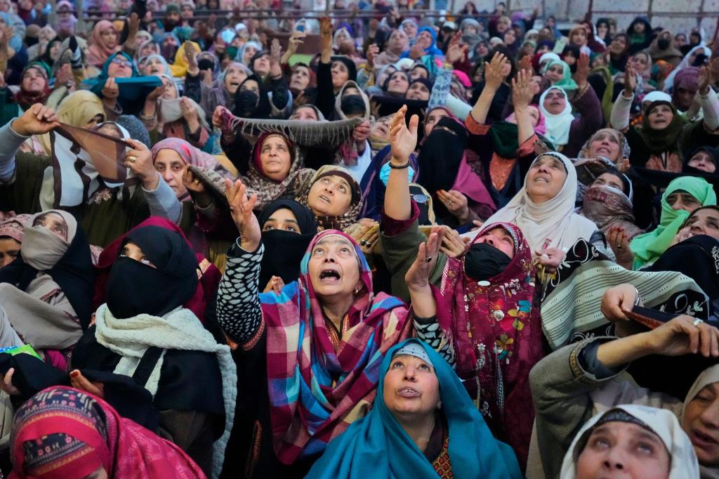 Muslimische Gläubige aus Kaschmir beten, während ein Oberpriester eine Reliquie zeigt. - Foto: Mukhtar Khan/AP/dpa