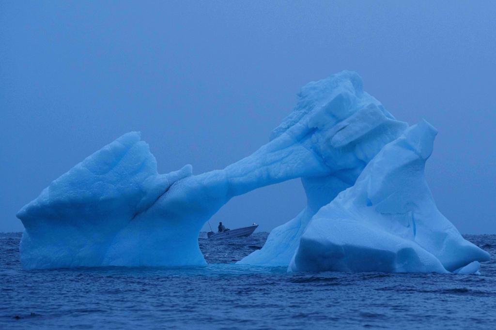 Ein Fischer navigiert vor der Küste von Nuuk in Grönland am Eis im Meer vorbei. - Foto: Evgeniy Maloletka/AP/dpa