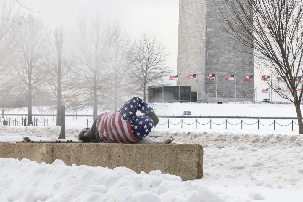 Ein Obdachloser ruht sich nach einem schweren Wintersturm in der Nähe des Washington Monuments auf. - Foto: Mehmet Eser/SOPA Images via ZUMA Press Wire/dpa