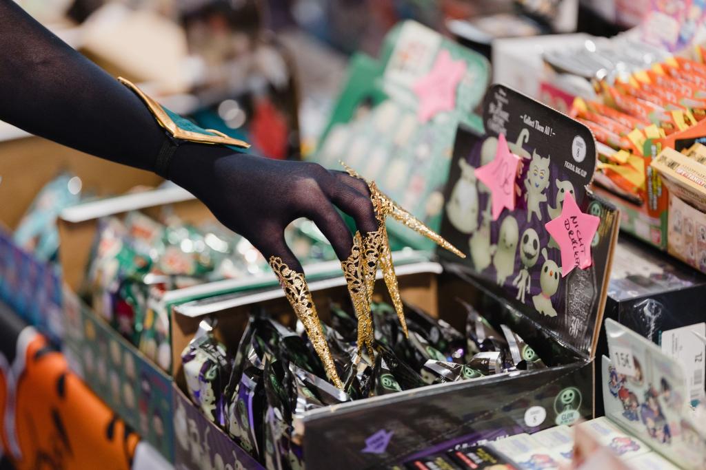 Eine verkleidete Messebesucherin berührt auf der Manga- und Comic-Messe «MAG-C» ausgestellte Produkte. - Foto: Michael Reichel/dpa